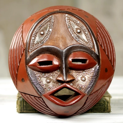 An African mask adorned atop a Handcrafted Circular West African Wall Mask in Red Tones, "Praise God".